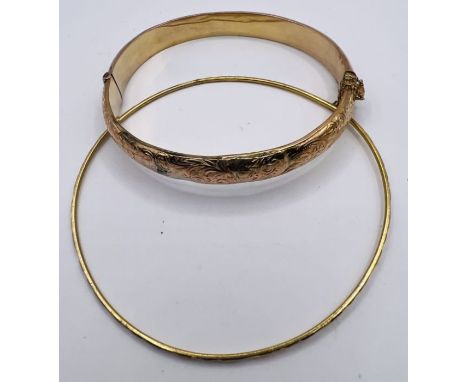 A 9ct gold hinged bangle, with a second unmarked yellow metal bangle. The 9ct bangle has an approximate weight of 8.4 grams, 