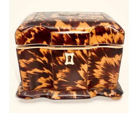 A George III tortoiseshell tea caddy, circa 1800, serpentine shape with a hinged lid revealing a single lifting interior lid 