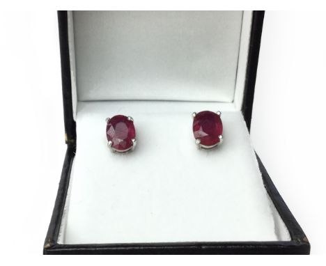 PAIR OF TREATED RUBY EARRINGS, each set with an oval ruby, with evidence of treatment, marked 925 to the posts, 1.7g