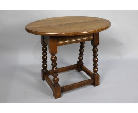 An Edwardian Oak Oval Topped Occasional Table with Bobbin Supports, 60cms wide 