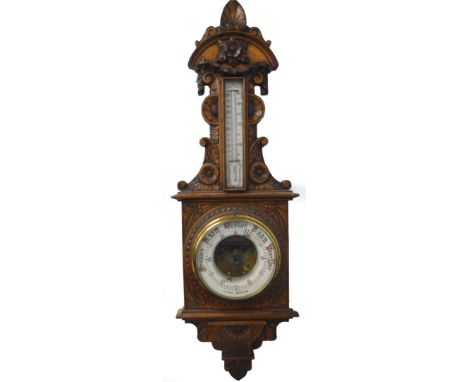 A late 19th/early 20thC carved oak barometer, with thermometer, stamped J Hall Bradford, 96cm long.