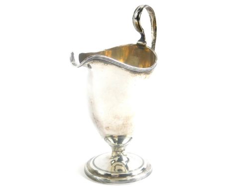 A George III silver helmet shaped cream cup, by Robert and David Hennell, with a reeded border and handle, on a stepped circu