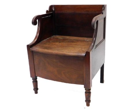 A 19thC mahogany commode, the raised back, scroll carved arm supports above a hinged seat, enclosing a recess on turned legs,