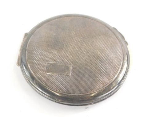 An Elizabeth II silver powder compact, of circular form, partially engine turned with vacant cartouche, fitted interior and t
