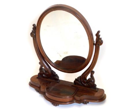 A Victorian mahogany dressing table mirror, the over plate on pierced carved supports, with shaped base with a central hinged