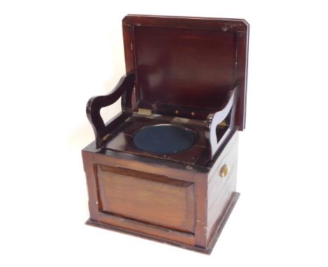 A Victorian walnut box commode, the hinged lid enclosing hinged arm rests, a recess, etc., above a panel front with brass sid