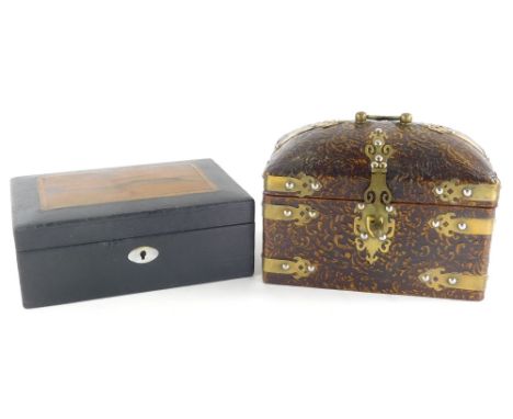 A pressed leather casket, of domed form with swing brass handle and brass mounts, with elaborate escutcheon and plain interio