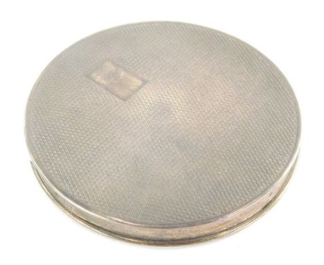 A mid 20thC silver Art Deco powder compact, of circular form, partially engine turned, with vacant cartouche and fitted inter
