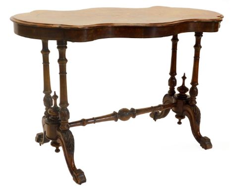 A Victorian figured walnut centre table, the shaped top with a central marquetry decoration of scrolls and leaves, on twin en