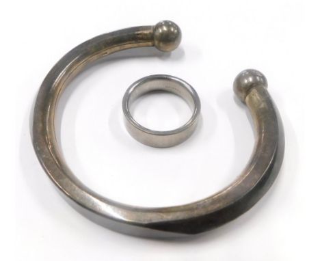 Two items of jewellery, to include a taupe bangle, white metal stamped 925, together with a gents Titanium signet ring. (2)