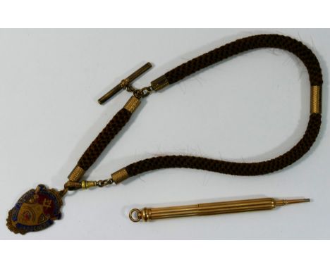 A gold plated propelling pencil, a woven hair watch chain with gold plated mounts and a gold plated and enamel medal from the