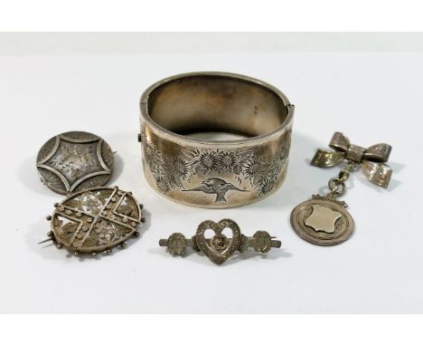 A Victorian silver hinged bangle, Birmingham 1883, and four Victorian and Edwardian silver brooches CONDITION REPORT: If you 