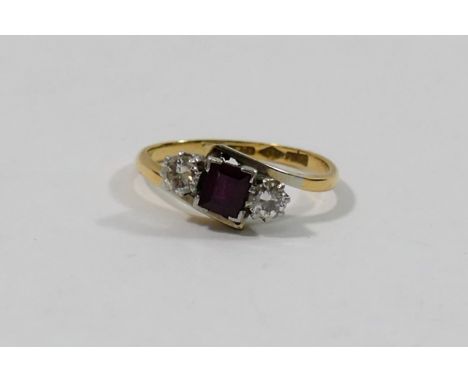 An 18 carat gold and platinum ruby and diamond three-stone ring, the step cut ruby set between two round brilliant cut diamon