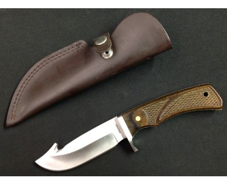 Hunting knife with 112mm long stainless steel blade, maker /retailer marked "Whitby". Chequered wooden grips with hole for la