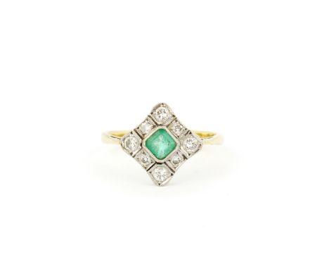 An antique 18ct yellow and white gold ring set with a square cut emerald surrounded by diamonds, (O). Gross weight approx. 3.