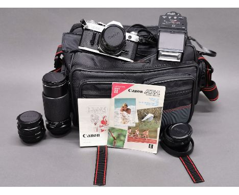 A Canon AE-1 camera with a Toqina 28MM lens, a Toqina-200MM lens and a Canon 50MM lens with flash and case.