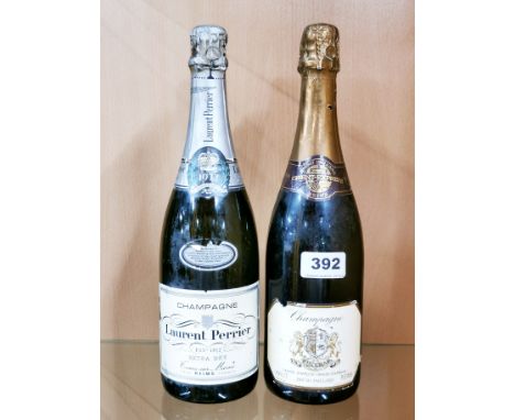 A 1977 vintage bottle of Laurent-Perrier champagne with a vintage bottle of Orient Express champagne.