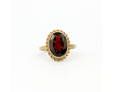 A hallmarked 9ct yellow gold ring set with a large oval cut garnet, L. 1cm, (Q.5). Gross weight approx. 3.4gr.&nbsp;