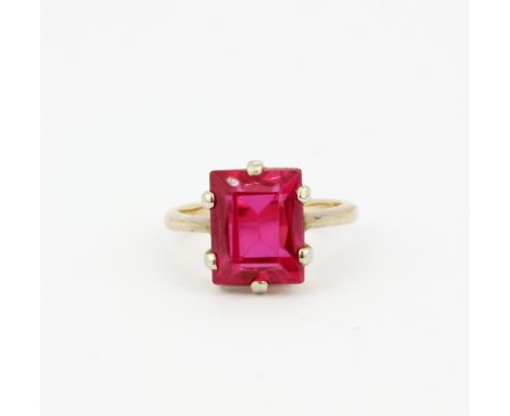 A 9ct yellow gold ring set with a large bevel cut synthetic ruby, (H.5).