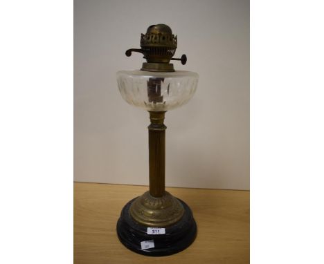 A vintage oil lamp having wheel cut glass reservoir, reeded-column and black ceramic base.