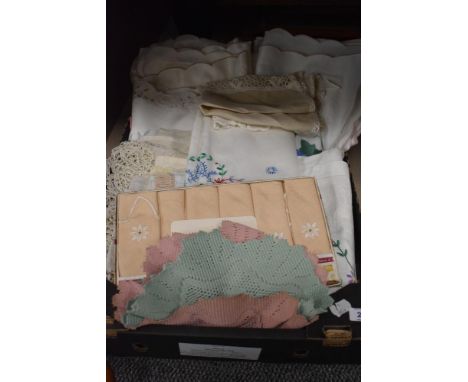 A quantity of vintage lace and embroidered table cloths, cushion covers, doilies and anti-macassars etc.