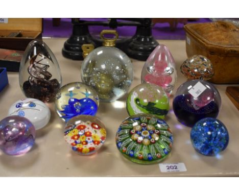 Twelve assorted paperweights including Caithness, Moon Crystal and Strathearn.