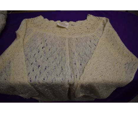 An assortment of vintage items, to include two jumpers, two aprons and a hat.