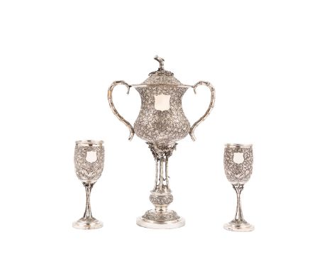 The larger h cm 37,5he cup features a circular double-tiered base, finely repoussé and chased with foliate motifs, surmounted