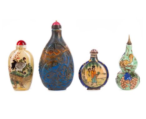 FOUR CHINESE SNUFF BOTTLES,the largest a blue and russet toned hardstone carved in low relief carp in lotus pond, 10.5cm high