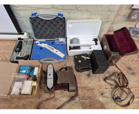 A box of assorted cameras and scientific instruments to include a Perkins tonometer mk2, an applination tonometer, Ensign Eps