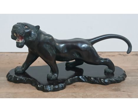 A Japanese Meiji Period bronze okimono modelled as a crouching tiger, character marks to belly, length 38cm, on wooden plinth