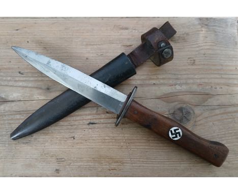 An Imperial/Third Reich German trench knife by Clement &amp; Jung, 14cm steel blade, wooden grip with enamel badge metal scab