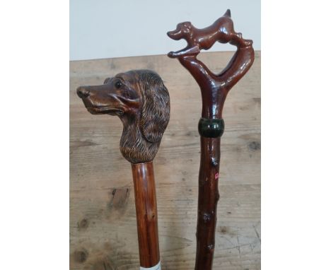 A walking stick with carved wood dog's head finial, the shaft marked GWI, length 129cm, and another similar.