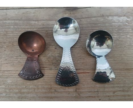 Three Lakeland Arts &amp; Crafts caddy spoons comprising two Keswick School of Industrial Arts and one Borrowdale, length 6cm