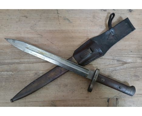 A WWI M95 bayonet by Ernst Busch, blade length 25cm, metal scabbard and leather frog, total length 38cm.
