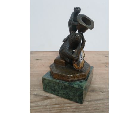 A 19thc century gilt bronze depicting a bear playing a cello with monkey sat on top and holding a top hat, green marble base,