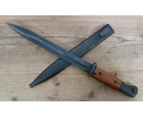 A German Third Reich K98 bayonet, blade length 24.5cm, wooden grip, metal scabbard, total length 40.5cm.