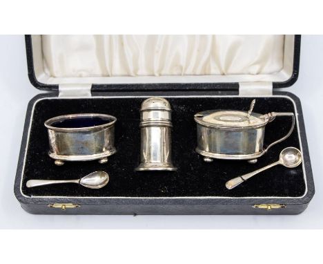 A Georgian style silver three piece condiment, comprising oval salt and mustard pot with cover and a pepper, with matching sp