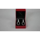 A pair of white metal (tests as platinum) and diamond articulated stirrup earrings with butterflies.