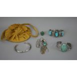 A collection of Native American turquoise jewellery with a yellow suede pouch. Including two