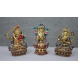 Three Tibetan gilded copper figures with hand painted detail and inlaid with coral and turquoise.