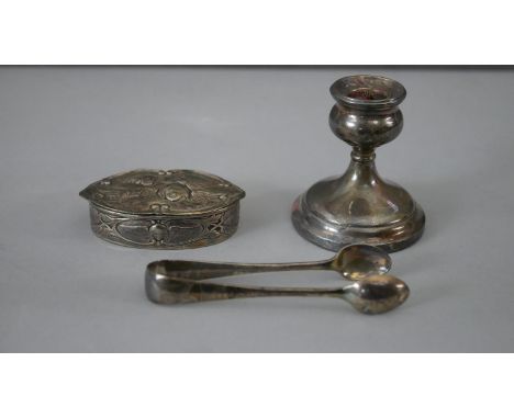 A collection of silver. Including a weighted silver candlestick, a pair of silver sugar tongs and a silver trinket box with r