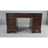 A Georgian style mahogany pedestal desk with inset tooled leather top on bracket feet. H.75 W.136