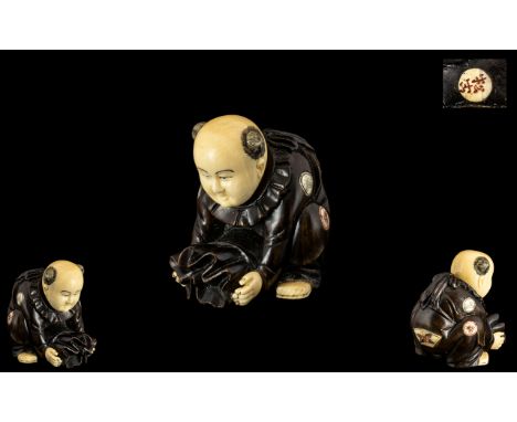 A Fine Quality Small Japanese Ivory and Carved Wood Netsuke Depicting a Small Boy Holding a Sack of Rice, With Inlaid Ivory R