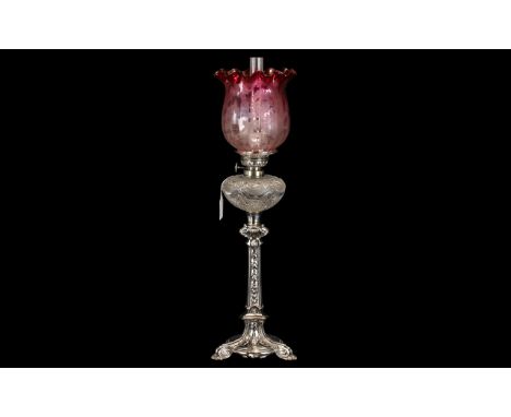 An Elegant Edwardian Silver Plated Oil Lamp in the French style with a finely cut glass font. With a ruby glass shade and fun