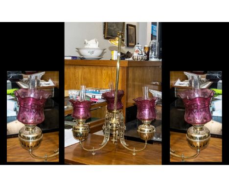A Three Branch Oil Lamp Chandelier, The Brass Fonts Supported by Shaped Gaselier Arms, Fitted with Ruby Red Glass Shades and 