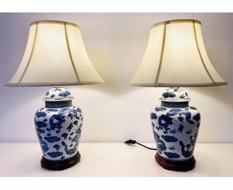 TABLE LAMPS, a pair, Chinese export style blue and white ceramic depicting dragon, with shaded, 60x40. (2) 