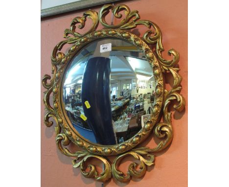 Gilt, scroll framed, convex wall mirror.