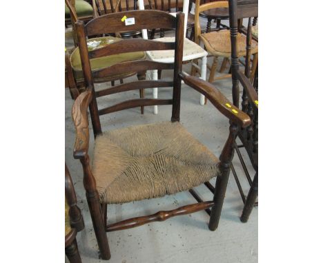 20th Century elm ladder back elbow chair with rush seat.