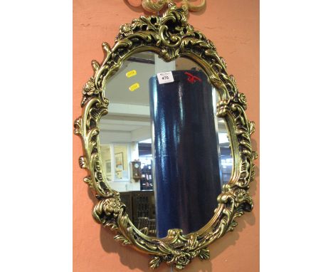 Modern gilt framed, oval, scroll wall mirror.